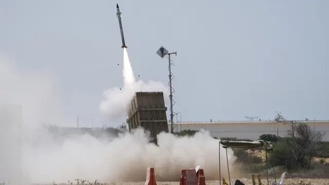 Seorang tentara Israel berlindung saat sistem pertahanan udara Iron Dome diluncurkan untuk mencegat roket yang ditembakkan dari Jalur Gaza di Ashkelon, Israel, 7 Agustus 2022. Israel telah