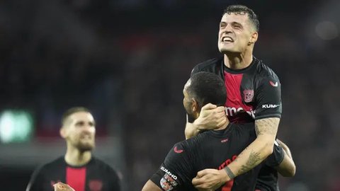 Pemain Bayer Leverkusen, Jonathan Tah melakukan selebrasi bersama Granit Xhaka setelah mencetak gol ke gawang Stuttgart pada laga perempat final DFB Pokal di Stadion di BayArena, Rabu