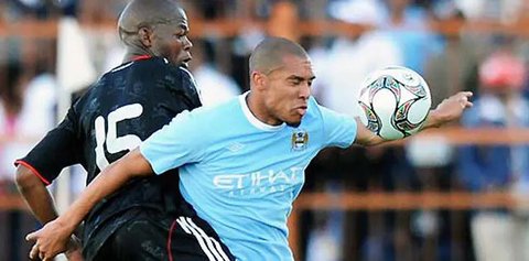 Gelandang Manchester City, Nigel de Jong dibayang-bayangi pemain Orlando Pirates, Ndumiso Mabena dalam partai persahabtan di Peter Mokaba Stadium, Polokwane, 18 Juli 2009. AFP