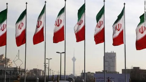Bendera Iran di luar gedung yang menampung reaktor fasilitas nuklir Bushehr di kota pelabuhan selatan Iran Bushehr pada tahun 2007 AFP / BEHROUZ MEHRI