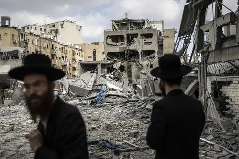 Warga mengamati apartemen yang rusak di Teheran, Iran, akibat serangan udara Israel pada Jumat (13/6/2025). (Dok. AP/Vahid Salemi)