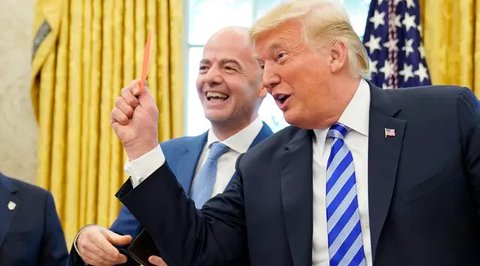 Presiden FIFA Gianni Infantino (tengah) tertawa saat Presiden AS Donald Trump memegang kartu merah selama pertemuan di Oval Office Gedung Putih pada Selasa (28/8). Presiden FIFA bertemu