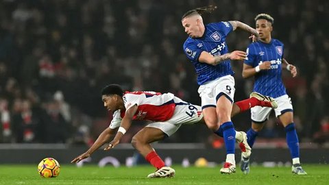 Pemain Arsenal, Myles Lewis-Skelly (kiri) berebut bola dengan pemain Ipswich Town, Kalvin Phillips pada laga lanjutan Liga Inggris 2024/2025 di Emirates Stadium, London, Inggris, Sabtu