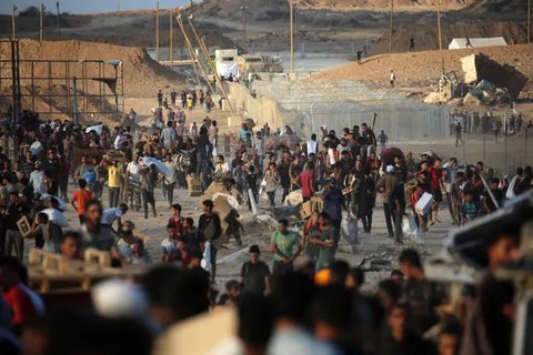 Warga Palestina berkumpul di titik distribusi bantuan yang didirikan oleh Yayasan Kemanusiaan Gaza (GHF) di dekat kamp pengungsi Nuseirat, Jalur Gaza Tengah pada 25 Juni 2025. (Eyad BABA/AFP)