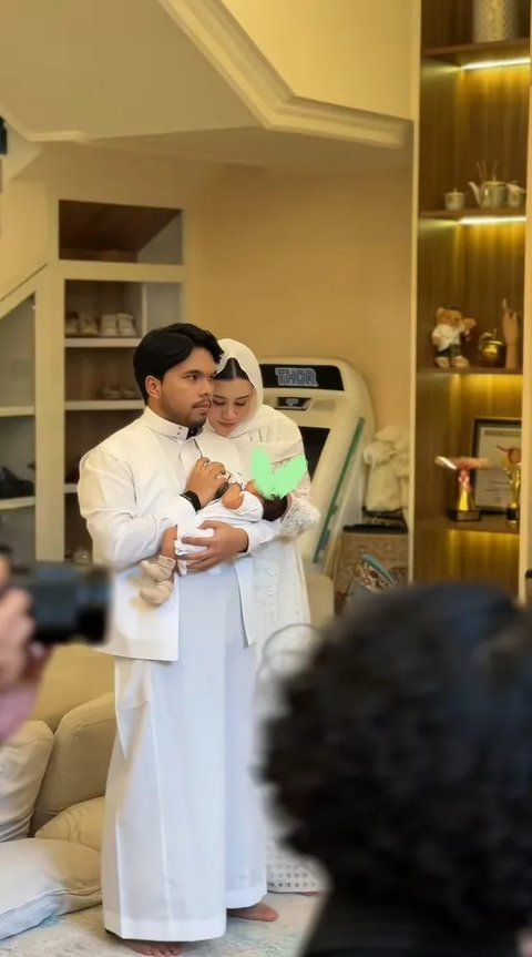 <p>Mengenakan baju muslim serba putih, Aaliyah dan Thariq tampak mengelus kepala sang buah hati selama memanjatkan doa.&nbsp;</p>