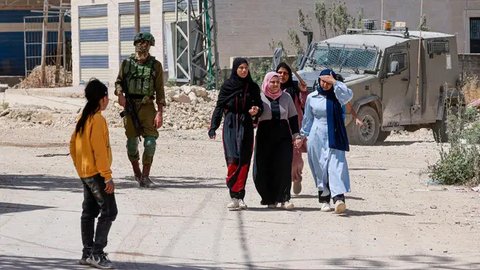 Dengan ketat, militer Israel mengawasi warga Palestina yang mengungsi meninggakan kamp pengungsi Tulkarem. (Jaafar ASHTIYEH/AFP)