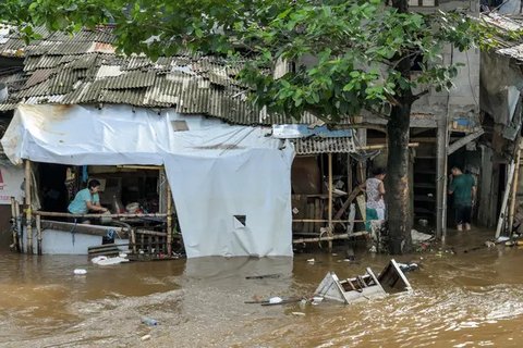 Tingginya intensitas hujan yang terjadi pada Minggu (6/7/2025) sore dan luapan air sungai terdekat menyebabkan banjir kembali melanda sejumlah wilayah Jakarta pada Senin pagi (7/7/2025). (BAY ISMOYO/AFP)
