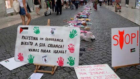 Sebuah instalasi pakaian dan mainan anak-anak tersebar di sepanjang jalan Carmo di pusat kota Lisbon, Portugal, Jumat, 30 Mei 2025. (AP Photo/Armando Franca)