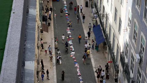 Sebuah instalasi pakaian dan mainan anak-anak tersebar di sepanjang jalan Carmo di pusat kota Lisbon, Portugal, Jumat, 30 Mei 2025. (AP Photo/Armando Franca)