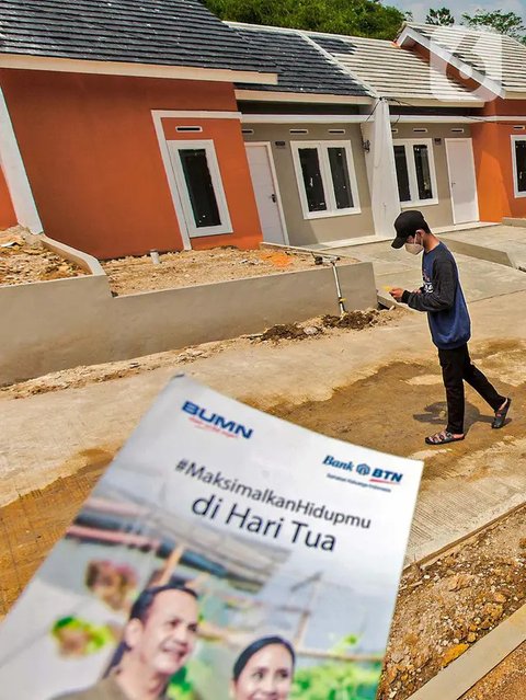 Warga berjalan di dekat pembangunan perumahan subsidi BTN di Kawasan Bogor, Jawa Barat, Jumat (18/2/2022). PT Bank Tabungan Negara (Persero) Tbk (BTN) memacu penyaluran Kredit Pembiayaan Ruma