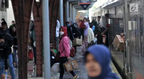 Seorang porter membawa barang penumpang kereta api Dharmawangsa dari Surabaya tiba di Stasiun Pasar Senen, Jakarta, Kamis (5/5/2022). Sebanyak 38.400 penumpang yang berangkat dari seluruh