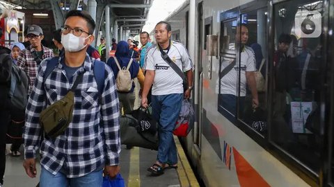 Seorang porter membawa barang penumpang kereta api Dharmawangsa dari Surabaya tiba di Stasiun Pasar Senen, Jakarta, Kamis (5/5/2022). Sebanyak 38.400 penumpang yang berangkat dari seluruh