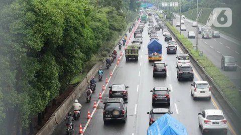 Pejalan kaki yang mengenakan masker berjalan di atas jembatan penyeberangan orang (JPO) dengan arus lalu lintas yang macet di kawasan Jalan TB Simatupang, Jakarta, Rabu (15/8/2023). Kement