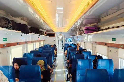 Penumpang menaikkan barang bawaan di dalam gerbong Kereta Api Jarak Jauh (KAJJ) di Stasiun Pasar Senen, Jakarta, Rabu (26/3/2025). (Liputan6.com/Herman Zakharia)