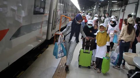 Penumpang menaikkan barang bawaan di dalam gerbong Kereta Api Jarak Jauh (KAJJ) di Stasiun Pasar Senen, Jakarta, Rabu (26/3/2025). (Liputan6.com/Herman Zakharia)