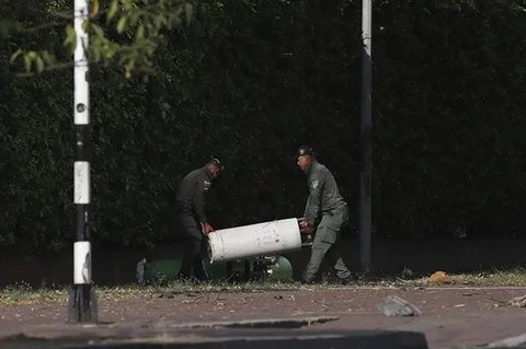 Tim forensik memeriksa lokasi ledakan bom di luar pangkalan Angkatan Udara di Cali, Kolombia, Kamis (21/8/2025). (Dok. AP/Santiago Saldarriaga)