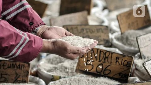 Pekerja menunjukkan beras yang akan dijual di toko beras di Pasar Kebayoran Lama, Jakarta, Jumat (5/5/2023). Kenaikan harga beras menjadi salah satu penyumbang inflasi Indeks Harga Konsumen p