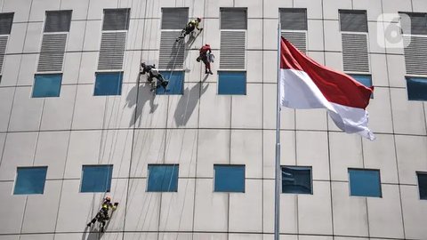 Seorang pekerja melakukan perawatan gedung perkantoran di kawasan Sudirman, Jakarta, Senin (30/11/2020). Menaker Ida Fauziyah menyatakan BSU BLT BPJS Ketenagakerjaan termin 2 tahap 6 senilai
