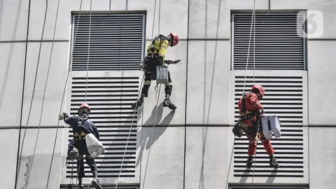 Seorang pekerja melakukan perawatan gedung perkantoran di kawasan Sudirman, Jakarta, Senin (30/11/2020). Menaker Ida Fauziyah menyatakan BSU BLT BPJS Ketenagakerjaan termin 2 tahap 6 senilai