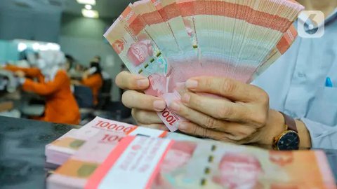 Karyawan menunjukkan uang rupiah dan dolar AS di Jakarta, Rabu (30/12/2020). Nilai tukar rupiah di pasar spot ditutup menguat 80 poin atau 0,57 persen ke level Rp 14.050 per dolar AS. (Liputa