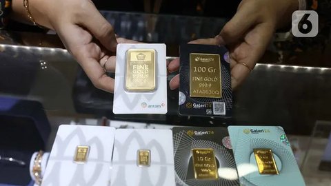 Petugas menunjukan emas batangan di kantor BNI Syariah, Jakarta, Senin (30/11). Harga jual-beli kembali (buyback) emas Antam turun Rp 1.000 usai akhir pekan kemarin naik di tengah turunnya ha