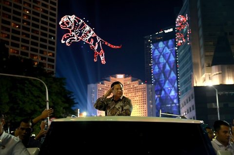 Presiden Prabowo Subianto menyapa warga dari atas mobil Maung MV 3 Garuda saat menghadiri malam Tahun Baru 2025 di kawasan Bundaran HI, Jakarta, pada Rabu (1/1/2025).