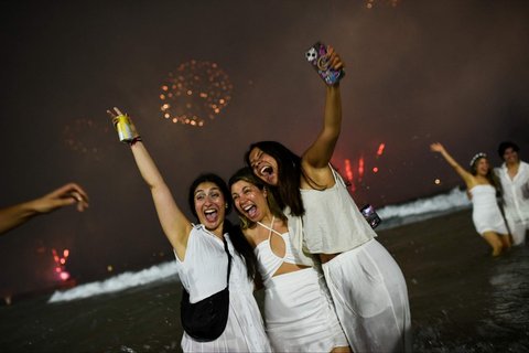 Orang-orang bersuka cita menikmati pesta kembang api selama perayaan malam Tahun Baru 2025 di Pantai Copacabana, Rio de Janeiro, Brasil, pada 1 Januari 2025.