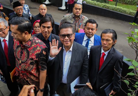 Hasto Kristiyanto tersenyum dan melambaikan tangan saat memenuhi panggilan penyidik di Gedung KPK Merah Putih, Jakarta, Senin (13/1/2025).