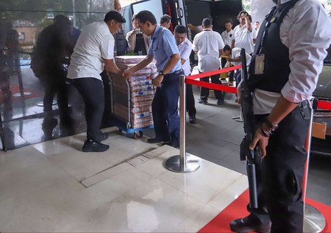 Petugas bersiap menampilkan tumpukan uang senilai Rp61 miliar yang menjadi barang bukti kasus judi online dalam konferensi pers di Mabes Polri, Jakarta, Senin (20/1/2025).