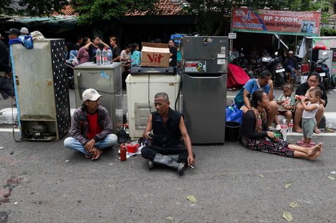 Sejumlah warga mengamankan barang-barangnya dari kebakaran di permukiman padat kawasan Jalan Kemayoran Gempol, Kemayoran, Jakarta, Selasa (21/1/2025).