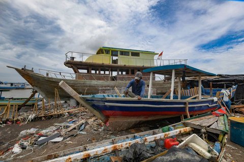 Warga menyelesaikan pembuatan perahu nelayan di Kampung Nelayan Tanjung Pasir, Tangerang, Banten, Rabu (22/1/2025).