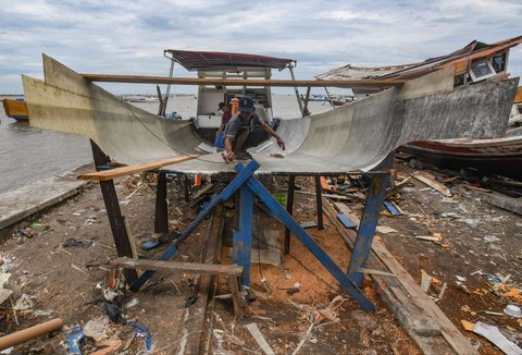 Warga menyelesaikan pembuatan perahu nelayan di Kampung Nelayan Tanjung Pasir, Tangerang, Banten, Rabu (22/1/2025).