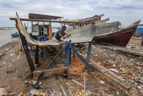Warga menyelesaikan pembuatan perahu nelayan di Kampung Nelayan Tanjung Pasir, Tangerang, Banten, Rabu (22/1/2025).