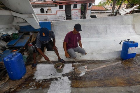 Warga menyelesaikan pembuatan perahu nelayan di Kampung Nelayan Tanjung Pasir, Tangerang, Banten, Rabu (22/1/2025).