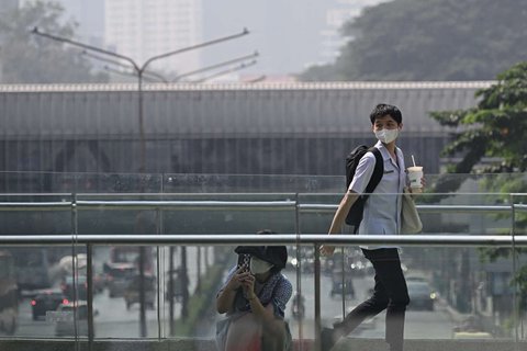 Sejumlah warga mengenakan masker pelindung ketika polusi udara tingkat tinggi tampak menyelimuti Ibu Kota Bangkok, Thailand, pada Jumat (24/1/2025).