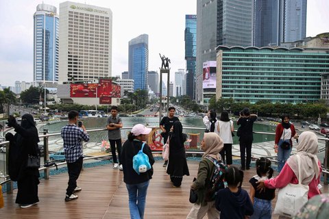 Sejumlah warga berfoto di Anjungan Halte Transjakarta Bundaran HI Astra, Jakarta, selama libur peringatan Isra Mikraj, Senin (27/1/2025).