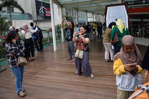 Sejumlah warga berfoto di Anjungan Halte Transjakarta Bundaran HI Astra, Jakarta, selama libur peringatan Isra Mikraj, Senin (27/1/2025).
