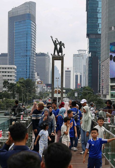Sejumlah warga berfoto di Anjungan Halte Transjakarta Bundaran HI Astra, Jakarta, selama libur peringatan Isra Mikraj, Senin (27/1/2025).