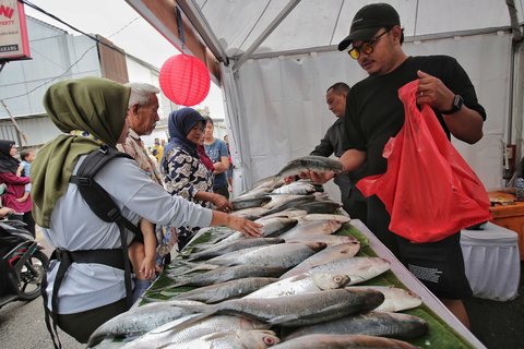 Sejumlah pengunjung memilih ikan bandeng saat berbelanja dalam Festival Bandeng Rawa Belong, Jakarta, Selasa (28/1/2025).
