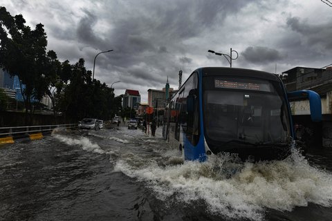 Bus TransJakarta melewati banjir yang merendam ruas Jalan Satria, Grogol, Jakarta Barat, Rabu (29/1/2025).