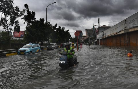 Pengemudi ojek online nekat melewati banjir yang merendam ruas Jalan Satria, Grogol, Jakarta Barat, Rabu (29/1/2025).