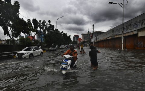 Sejumlah pengendara nekat melewati banjir yang merendam ruas Jalan Satria, Grogol, Jakarta Barat, Rabu (29/1/2025).