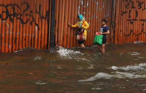 Sejumlah warga berjalan melewati banjir yang merendam ruas Jalan Satria, Grogol, Jakarta Barat, Rabu (29/1/2025).
