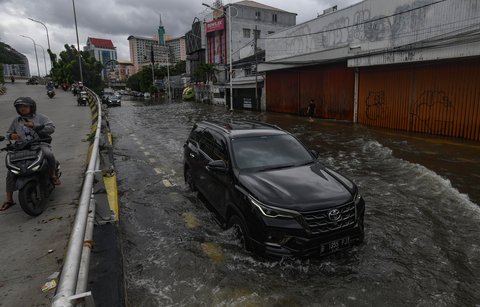 Sejumlah pengendara melewati banjir yang merendam ruas Jalan Satria, Grogol, Jakarta Barat, Rabu (29/1/2025).
