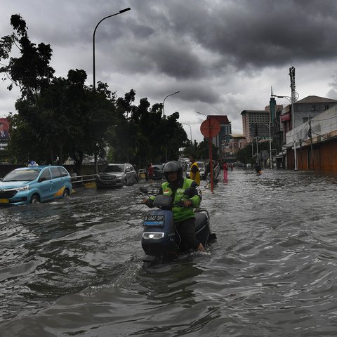 Bus TransJakarta melewati banjir yang merendam ruas Jalan Satria, Grogol, Jakarta Barat, Rabu (29/1/2025).