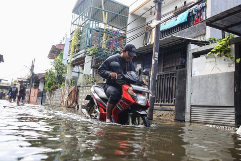 Pengendara sepeda motor nekat menerobos banjir yang merendam pemukiman penduduk di kawasan Cengkareng Barat, Jakarta Barat, Kamis (30/1/2025).