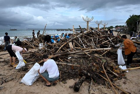 Relawan dan wisatawan membersihkan sampah plastik yang terdampar di pantai Kedonganan, Kabupaten Badung, Pulau Bali, Indonesia, (04/01/2024)