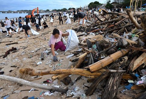 Relawan dan wisatawan membersihkan sampah plastik yang terdampar di pantai Kedonganan, Kabupaten Badung, Pulau Bali, Indonesia, (04/01/2024)