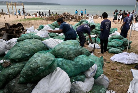 Relawan dan wisatawan membersihkan sampah plastik yang terdampar di pantai Kedonganan, Kabupaten Badung, Pulau Bali, Indonesia, (04/01/2024)