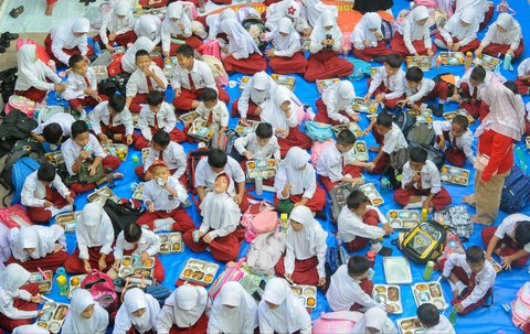 Sejumlah siswa menikmati Makan Bergizi Gratis (MBG) di SDN Lengkong Wetan 01, Tangerang Selatan, Banten, Senin (6/1/2024).